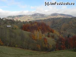 P06 [NOV-2012] În zare se vede creasta Măgurii Branului şi satul Măgura, cu casele înşirate cam pe linia umbrei. Chiar şi valea de jos (Valea cu Calea), deşi la doi paşi de Peştera, cred că aparţine de Măgura. În tot cazul, singurul drum circulabil pe acea vale vine dinspre Măgura. În poză am încercat să evidenţiez frumoasele culori autumnale dar, fiind afon în domeniu, am reuşit să estompez cerul.